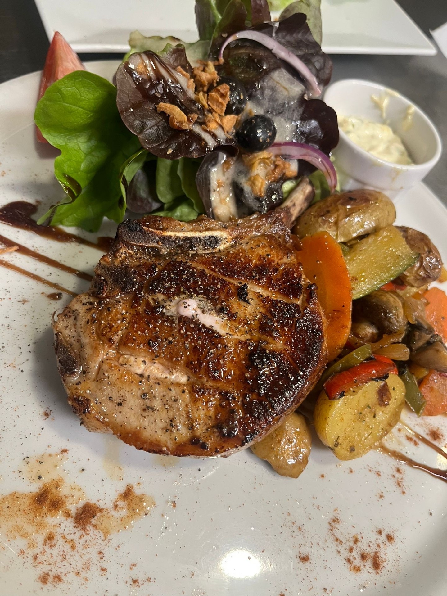 Côte de porc grillée, légumes et salade